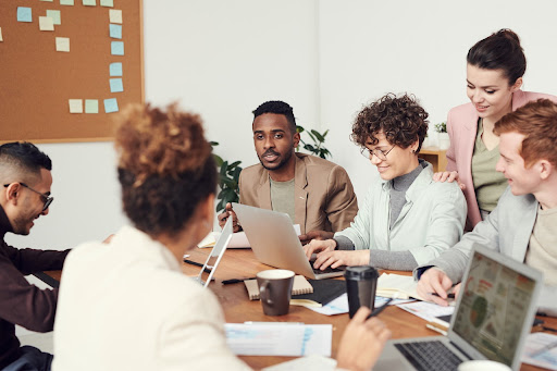 A group ps people in a meeting in a formal office setting.